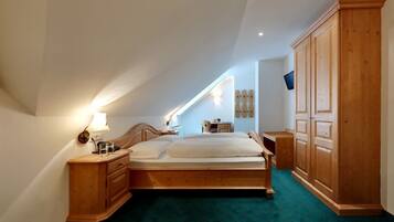 Une chambre à coucher avec un lit en bois, une table de chevet, une commode et une armoire.