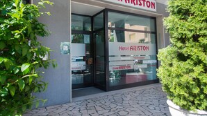 La entrada de un hotel con un cartel que dice "Hotel ARISTON" y el número "82" encima.