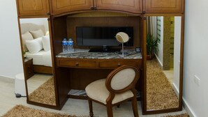 A compact, wooden-built study area with a desk, chair, and a television. - Paris Hotel (Cairo)