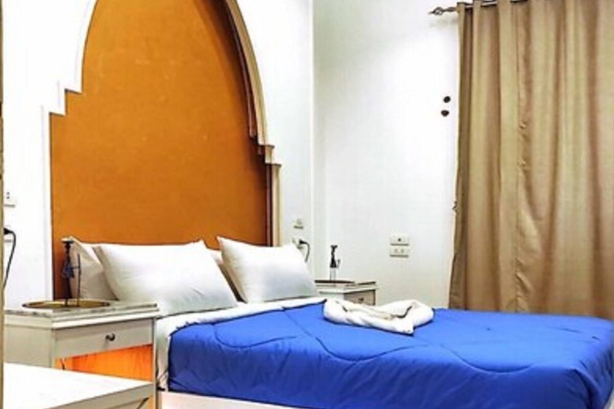 Ein Schlafzimmer mit einem Bett, einem Nachttisch, einer Kommode und Holzboden.