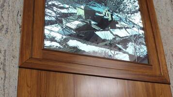 A framed photograph of a mountainous landscape with a wooden cabinet below.