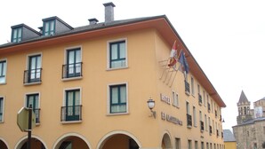 A yellow building with the sign "HOTEL EL CASTILLO" and multiple windows. - El Castillo (Ponferrada)
