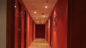 A long, narrow hallway with wooden floors and red walls. - El Castillo (Ponferrada)