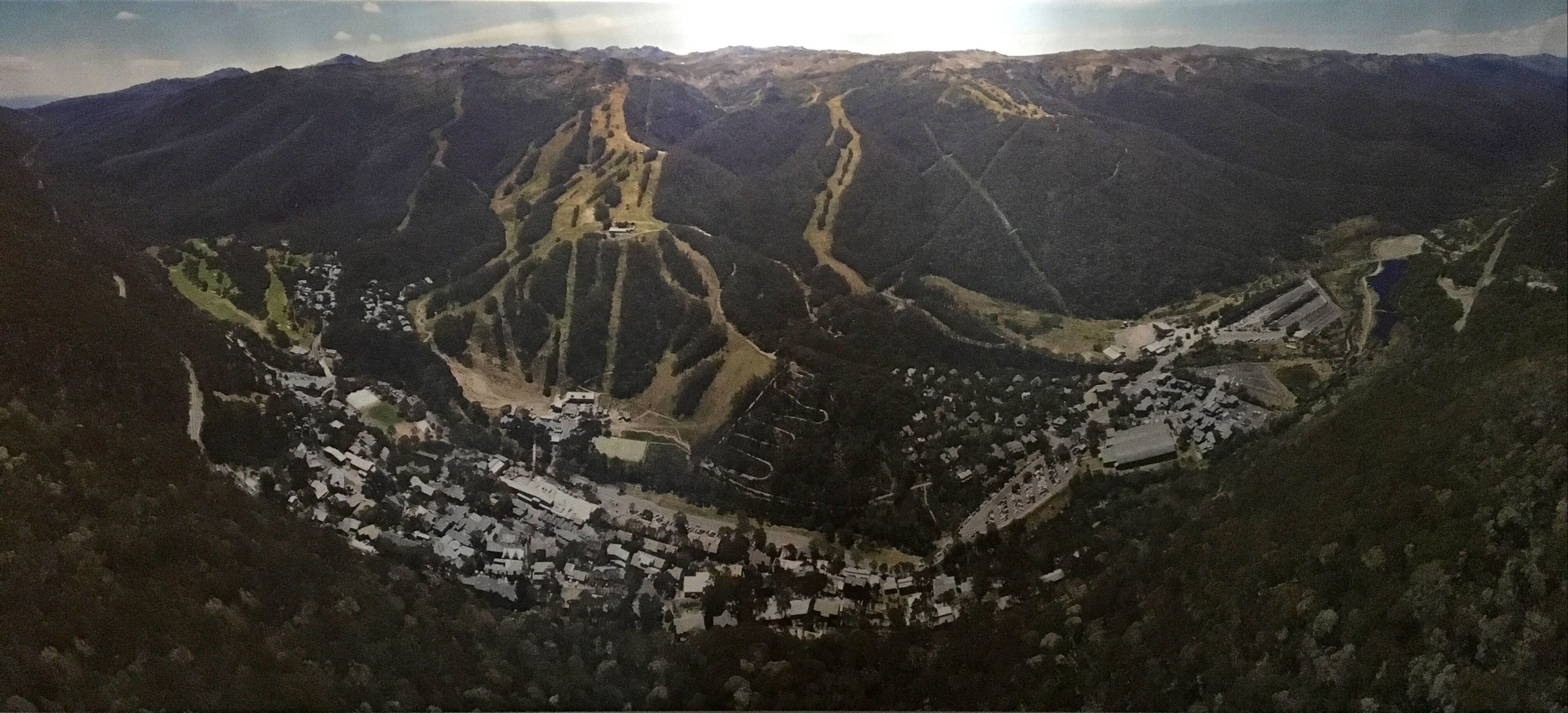 A mountainous landscape with a valley containing a small town with houses and roads.