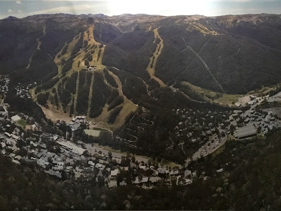 A mountainous landscape with a valley containing a small town with houses and roads.