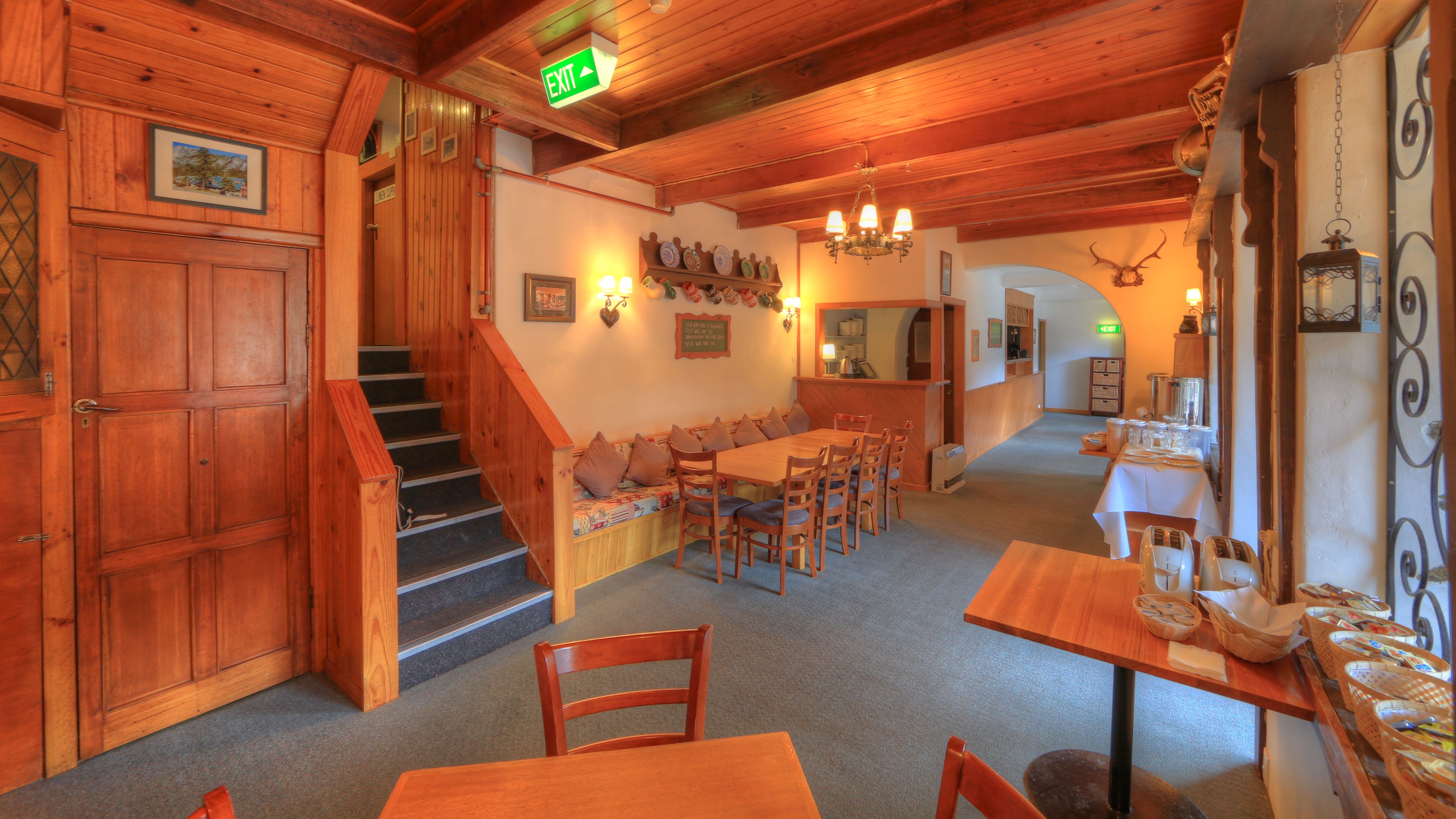 Un intérieur en bois comprenant un escalier, un coin repas et une cuisine.
