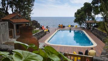 Alberca al aire libre y camastros