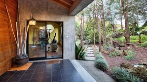 A modern building with a wooden interior and a glass door leading to a garden.