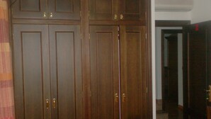 A wooden wardrobe with two doors and a mirrored closet door.