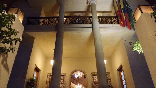 A building with two large columns, a balcony with railings, and several flags. - Hotel Don Alfonso (Pereira)
