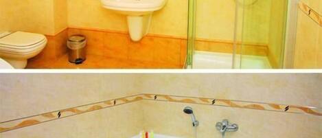 A bathroom with a sink, toilet, and glass-enclosed shower.