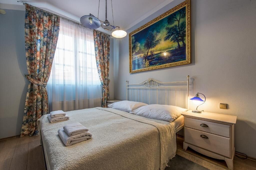 Une chambre à coucher avec un lit, une table de chevet et un tableau accroché au mur.