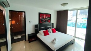 Un hotel moderno con una cama grande, una mesita de noche, una obra de arte en la pared y vistas de la ciudad a través de amplios ventanales.