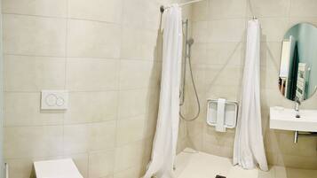 Een moderne badkamer met een douche, wastafel en spiegel.