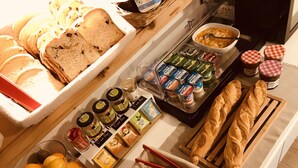 A breakfast buffet with various food items including bread, pastries, and condiments. - Résidence Thibaud (Toulouse)
