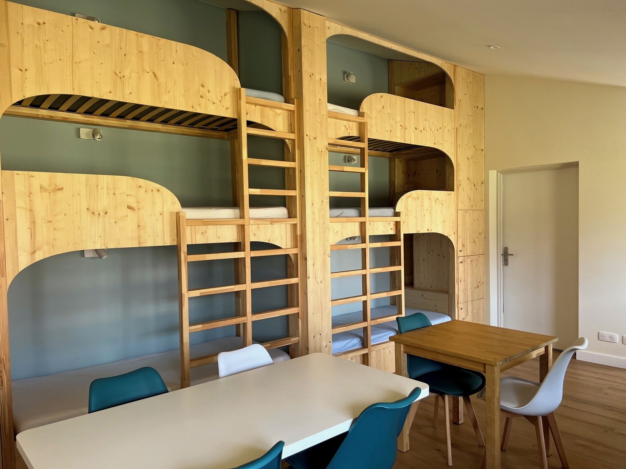 Une pièce avec des lits superposés, une table et des chaises.