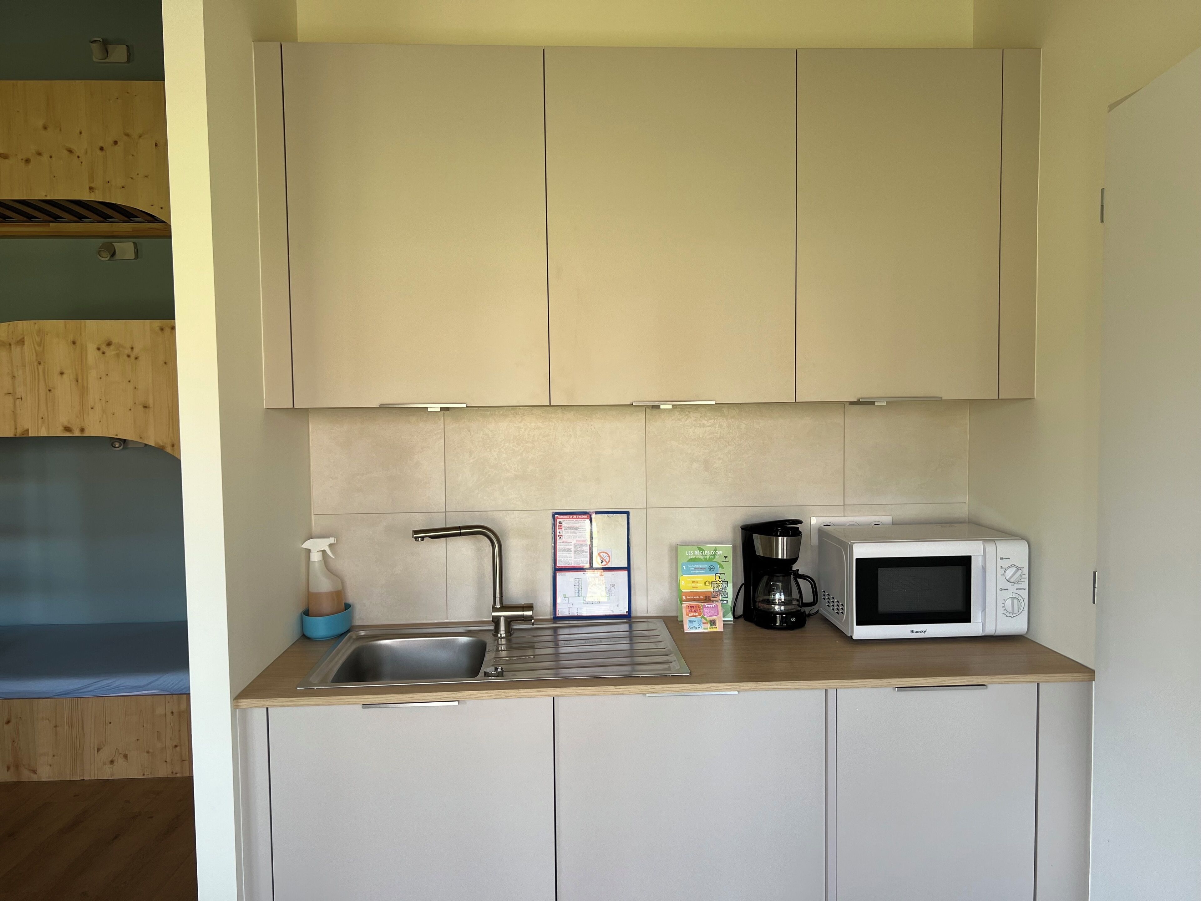 A compact kitchenette with a sink, a coffee maker, and a microwave.