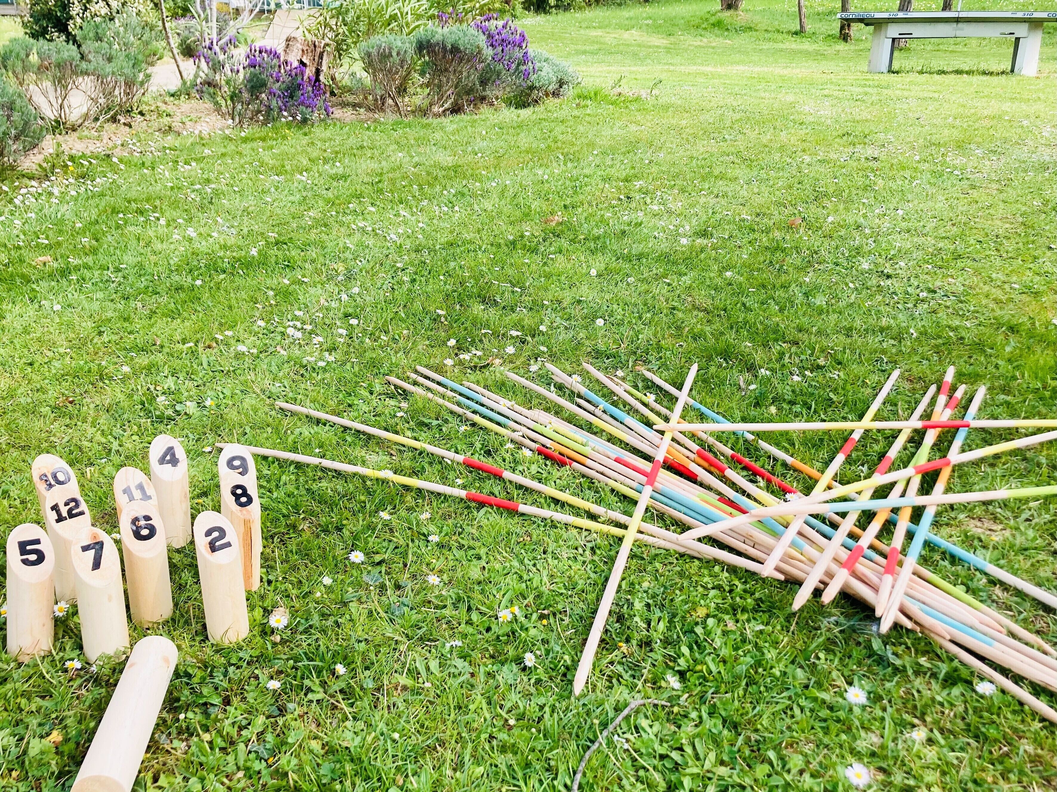 Ein grasbewachsenes Gelände mit nummerierten Holzpfählen und einem Haufen Stöcke mit farbigen Enden.