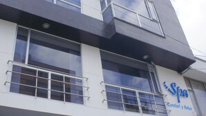 En moderne hotelbygning med flere etager, store vinduer og altaner.