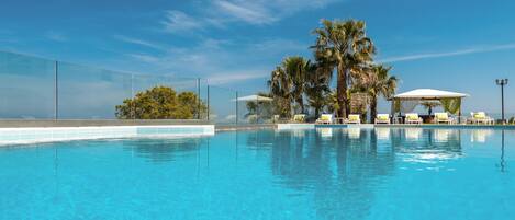 Piscine extérieure, parasols de plage, chaises longues