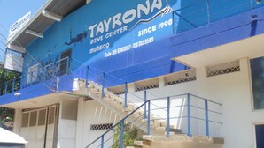 Un bâtiment à la façade bleue, sur lequel on peut lire l’inscription : « Centre de plongée TAYRONA, fondé en 1990 ».