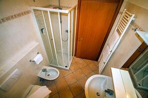 A bathroom with a shower enclosure, a sink, a bidet, and a toilet. - Albergo Lario (Gera Lario)