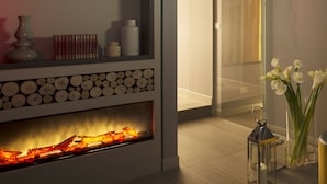 Una sala de estar moderna con chimenea, estanterías y un ventanal que da a un balcón.