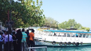 A boat docked at a pier with people standing on the adjacent walkway. - Kaani Lodge (Malé)