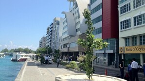 A waterfront hotel with modern architecture, a paved walkway, and a view of the sea. - Kaani Lodge (Malé)