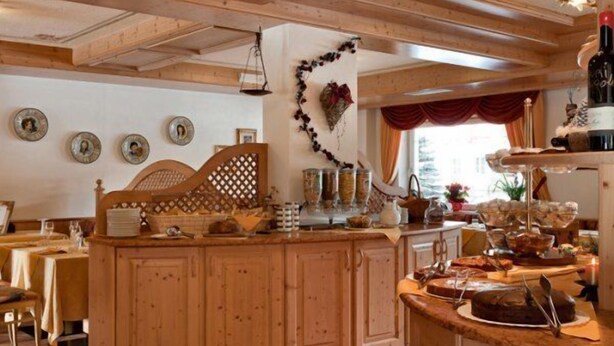 Un interior de madera con un mostrador de buffet, armarios de madera y un adorno en la pared.
