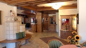 Amplia sala de estar con chimenea, techo de madera y una mesa de comedor con girasoles.
