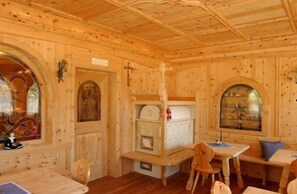 A wooden interior with a high ceiling, arched windows, and a small altar. - Alpen Hotel Panorama (Campitello di Fassa)