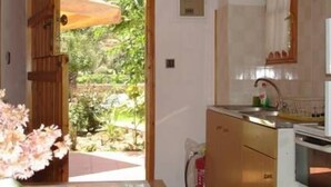 Une cuisine avec une porte en bois donnant sur un jardin.