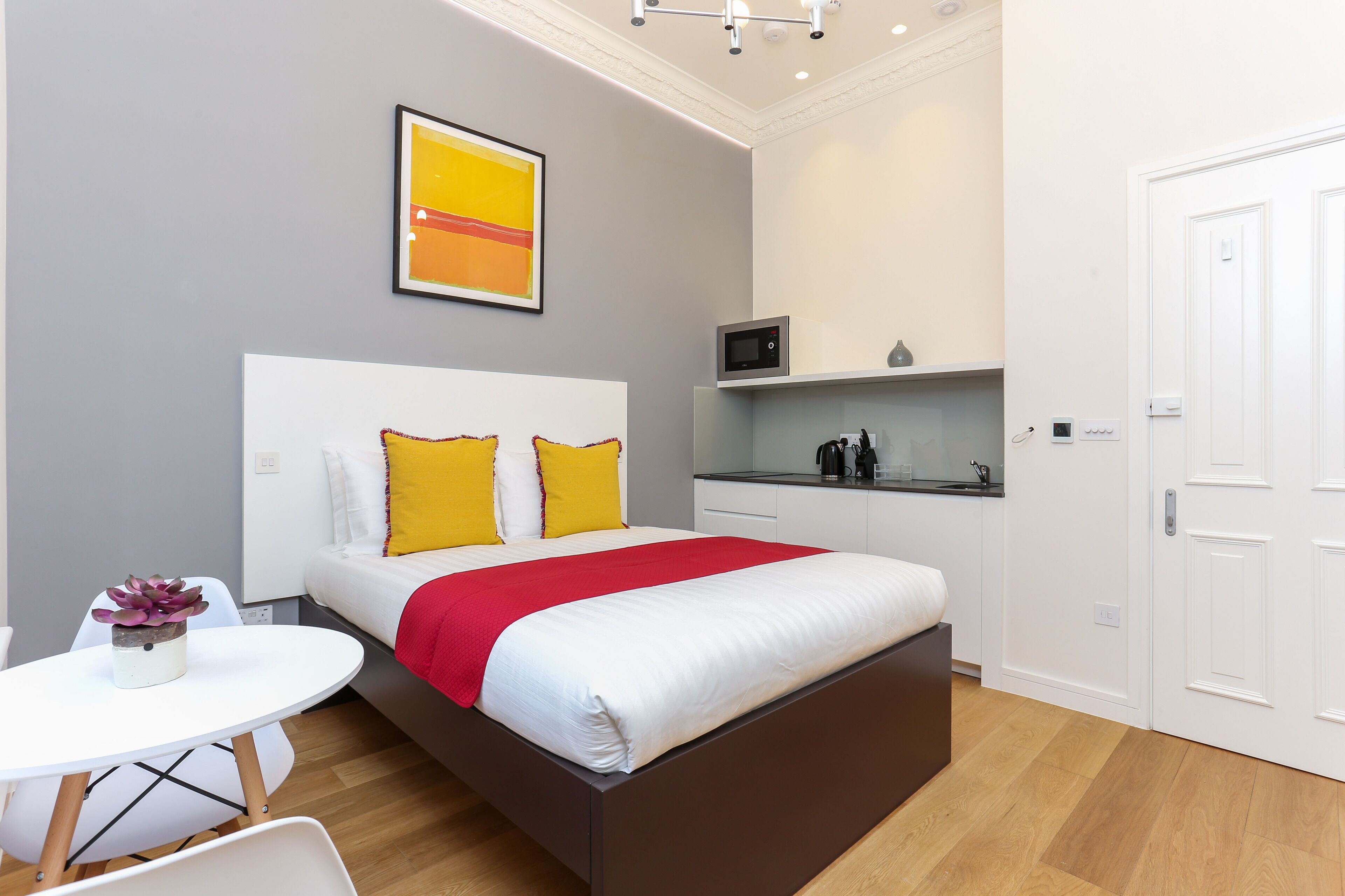 Une chambre à coucher moderne avec un lit, une table de chevet et un petit coin salon.