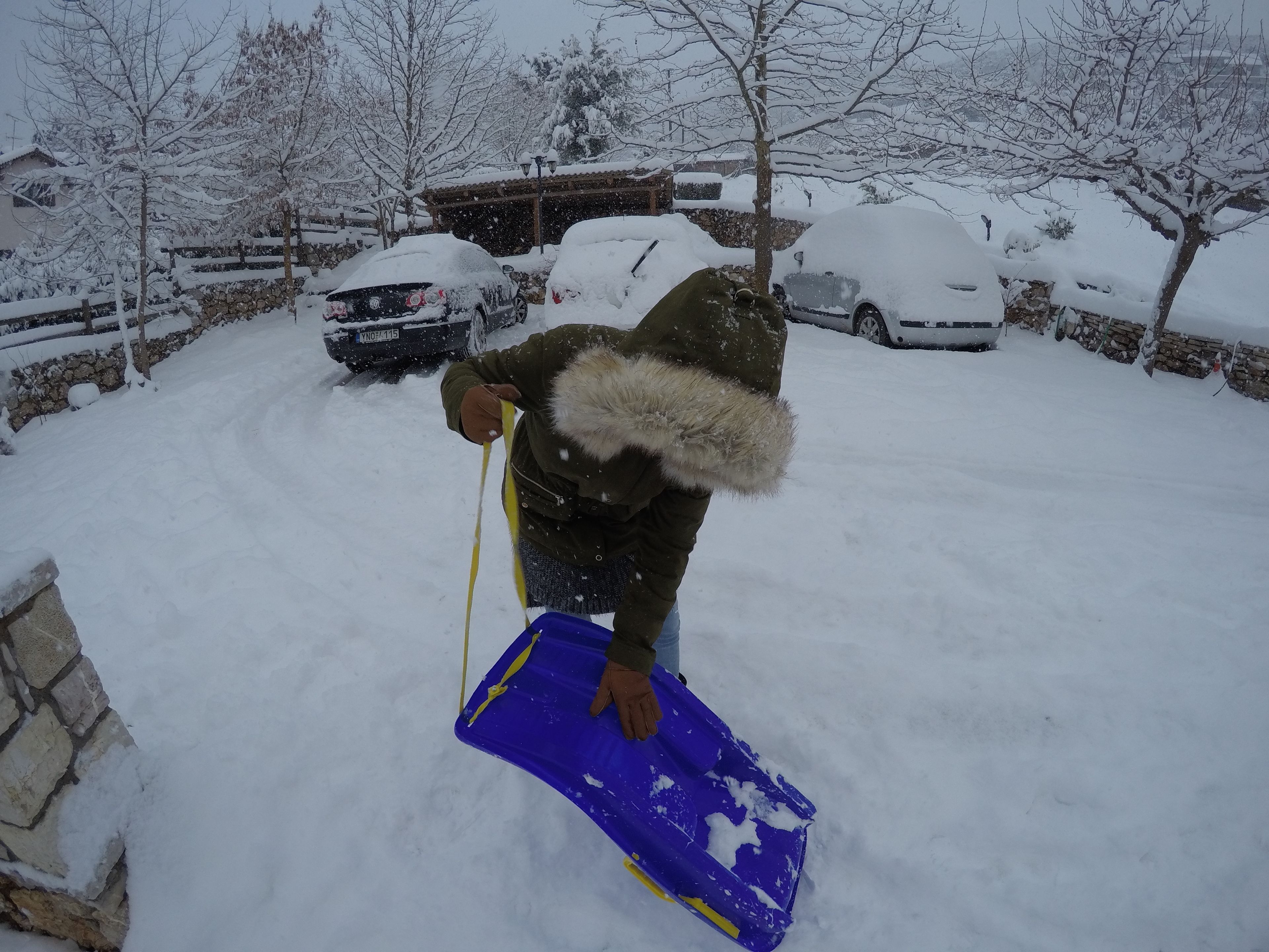Une personne qui déneige une allée.