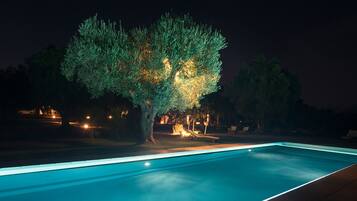 Una piscina al aire libre de temporada, sombrillas