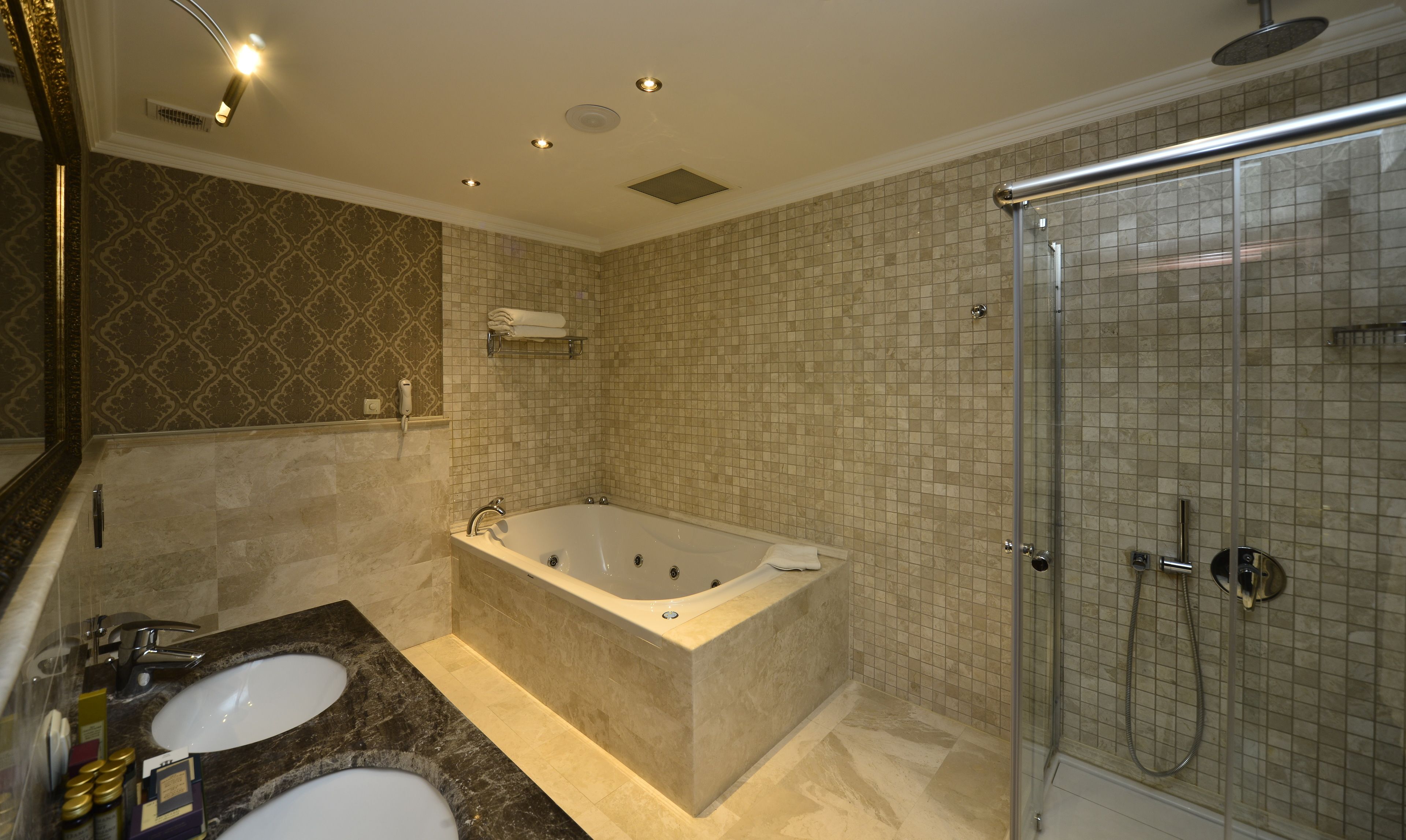 A modern bathroom with a freestanding bathtub, a glass-enclosed shower, and a vanity with two sinks.