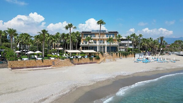 A beachfront hotel with a pool area, multiple floors, and a beach with umbrellas. - Villa Augusto Boutique Hotel - Boutique Class (Alanya)