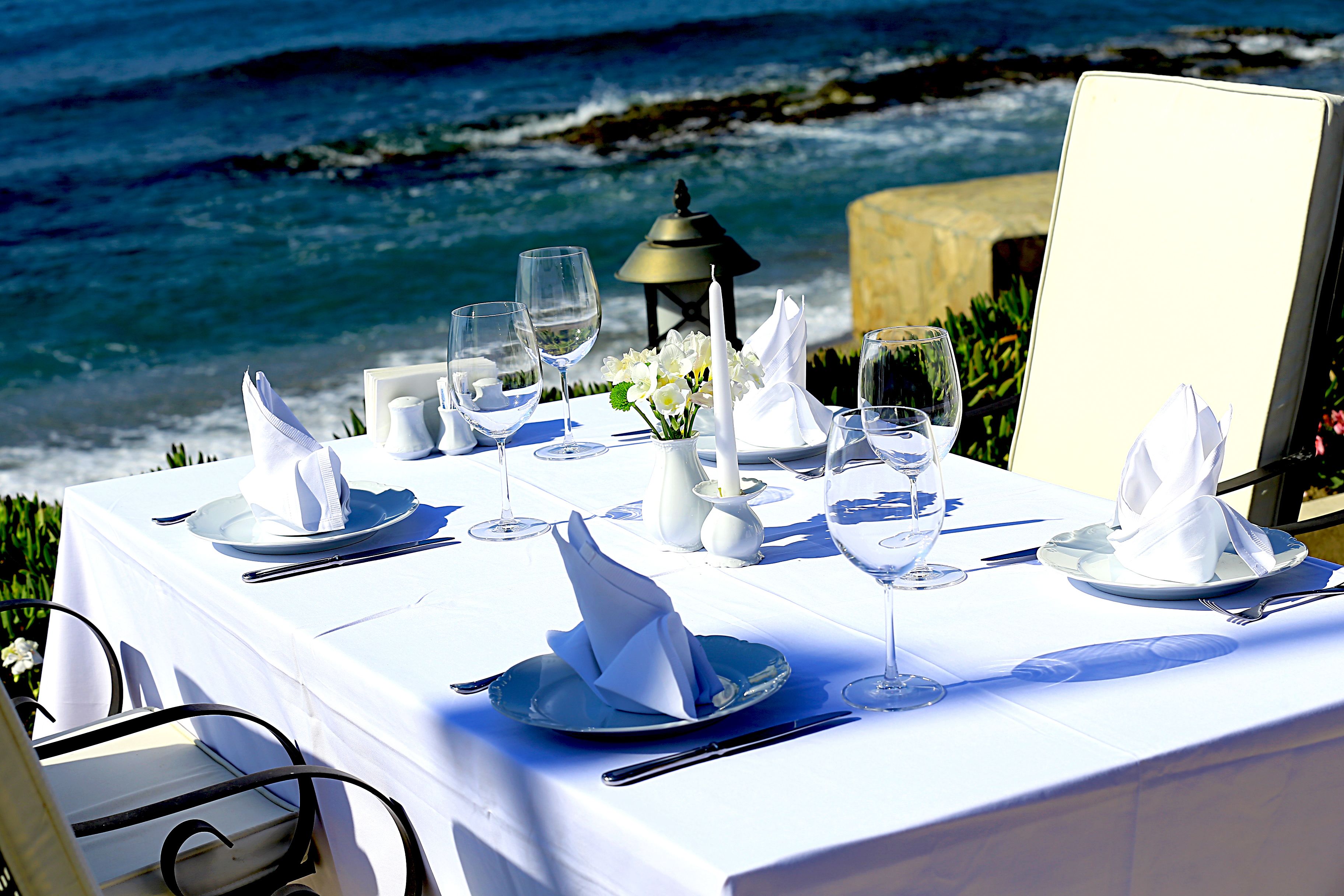 A table set for a meal with a view of the ocean.