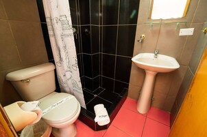 Un baño con inodoro, ducha y lavamanos.