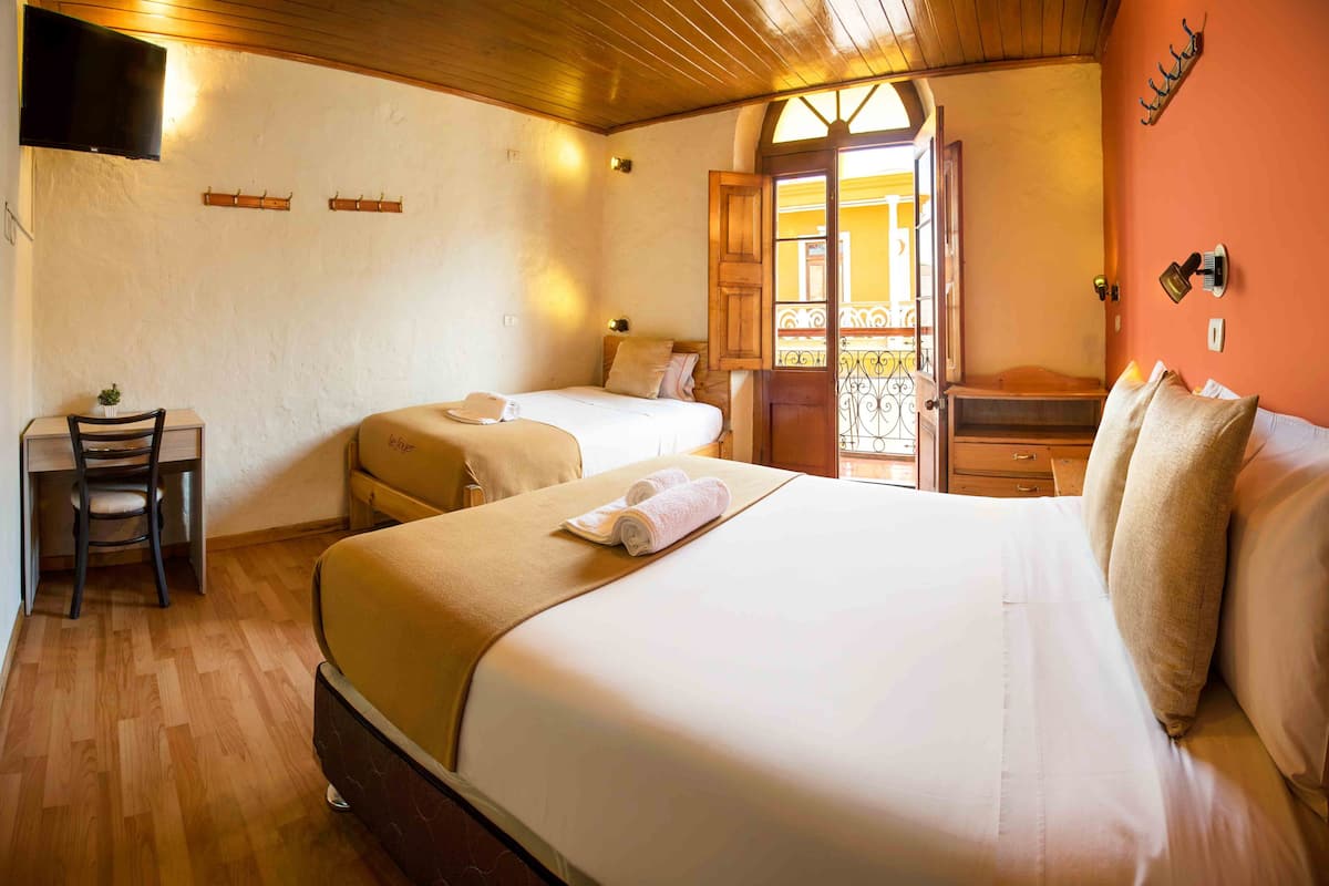 A room with two beds, a desk, and a chair.