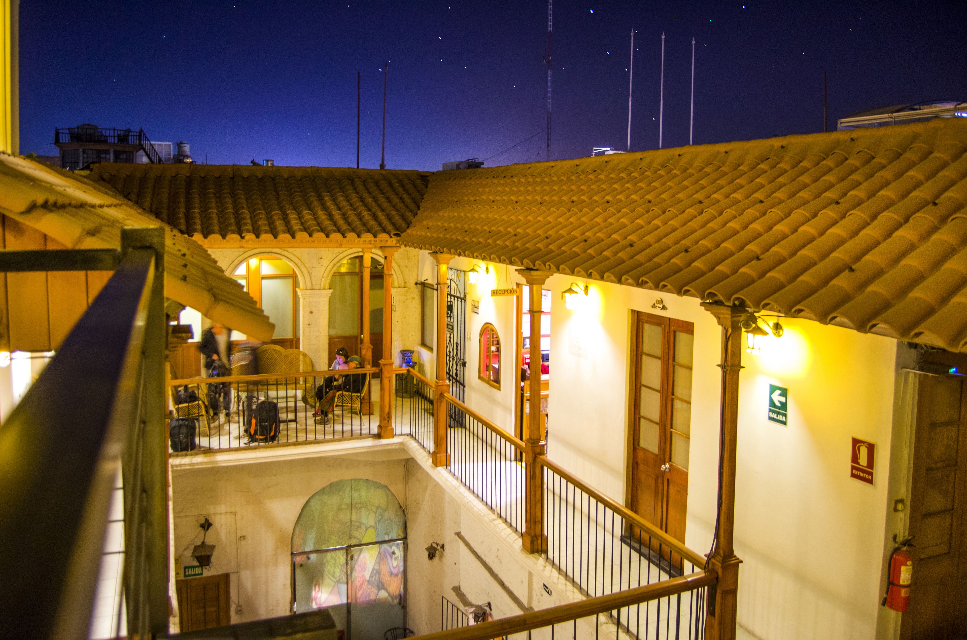 Un edificio histórico con un patio, una escalera y vistas al cielo nocturno.