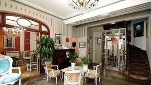 A spacious lobby with a grand staircase, a reception desk, and comfortable seating areas. - Hotel Crystal Reims Centre (Reims)