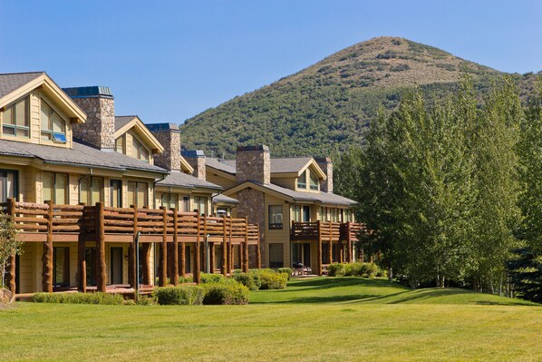 A hotel with a stone facade, multiple balconies, and a well-maintained lawn. - Deer Valley's Signature Collection (Park City)