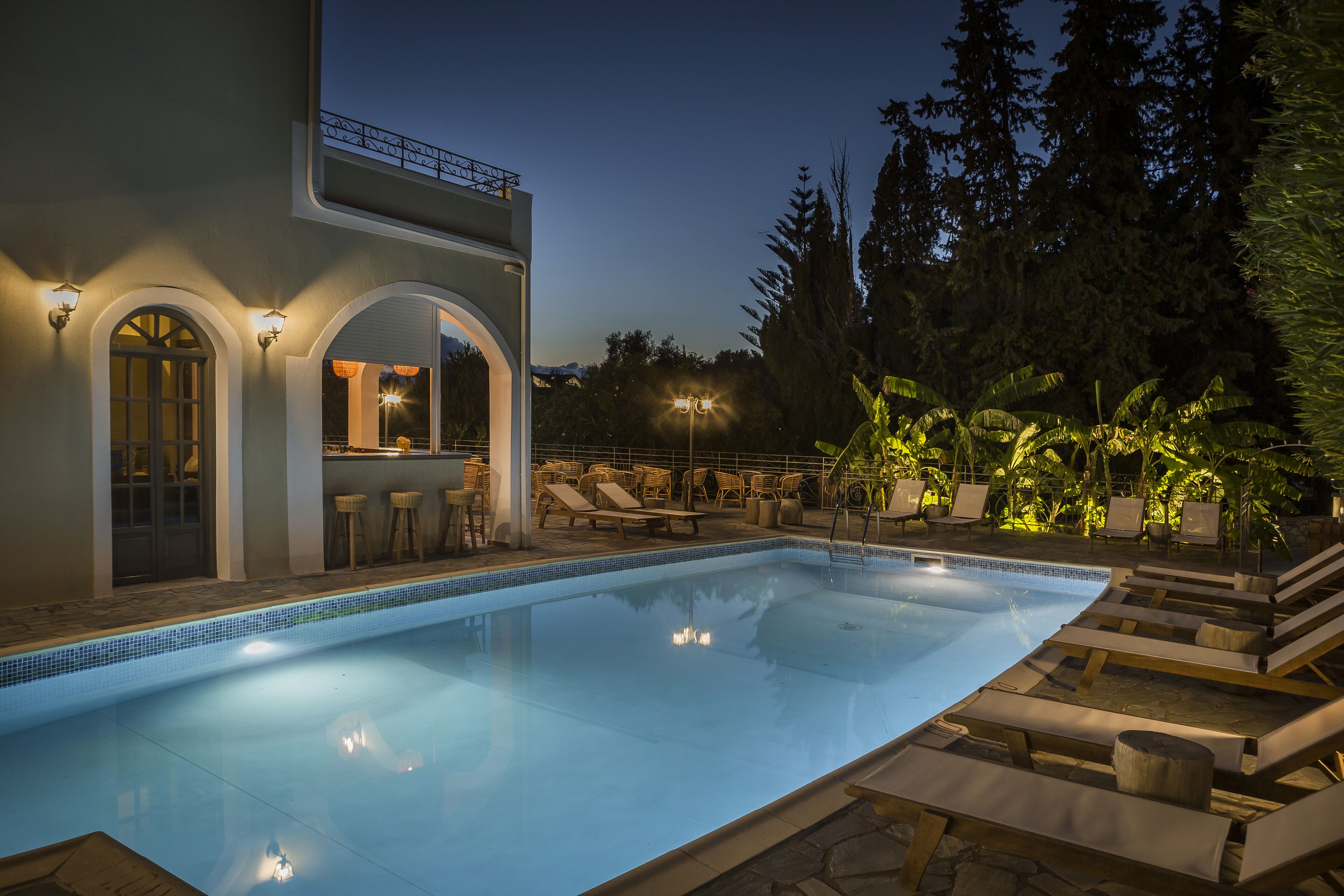 A swimming pool with lounge chairs and a bar area.