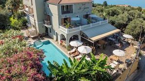 Un hotel con piscina, mobiliario exterior y vistas al mar.