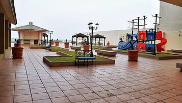 Relax in a serene outdoor space with benches, a gazebo, and a play area for kids.