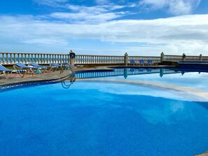 Alberca al aire libre, sombrillas en la alberca y camastros 