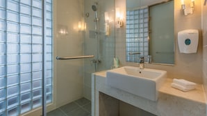 A modern bathroom with a glass shower enclosure, a white sink, and a hand dryer. - Holiday Inn Express Tianjin Heping by IHG (Tianjin)