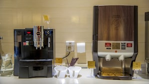 A coffee station with two coffee machines, a hot water dispenser, and sugar and coffee dispensers. - Holiday Inn Express Tianjin Heping by IHG (Tianjin)